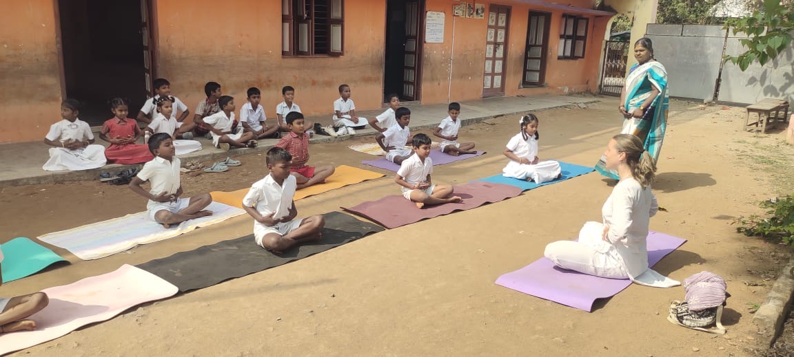 A school group seated on yoga mats during a Violets Project wellbeing session